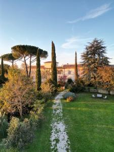 a garden with cypress trees and a building at Borgo Rinascimento in Farnese