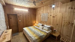 a bedroom with a bed in a wooden wall at Aroha Living in Bandal