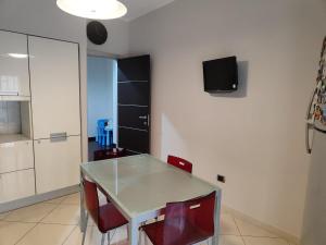 a dining room with a table and red chairs at Dimora C&A in Mondragone