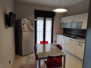 a small kitchen with a table and a refrigerator at Dimora C&A in Mondragone