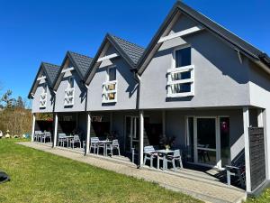 a house with chairs and tables on a lawn at Poprzeczna 7 in Sarbinowo