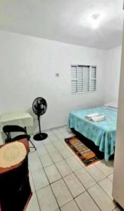 a room with a bed and a table in it at Hospedagem Aeroporto in Campinas