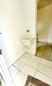 a bathroom with a sink and a tiled floor at Hospedagem Aeroporto in Campinas +3 photos