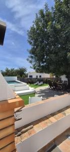 a view of a yard with a tree and benches at Cosy Country House in Cerro da Cova