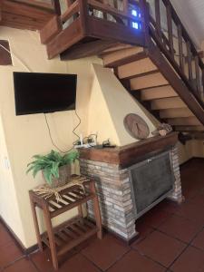 a living room with a tv and a fireplace at La Rocca in Colón