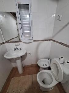 a white bathroom with a toilet and a sink at La Rocca in Colón +14 photos