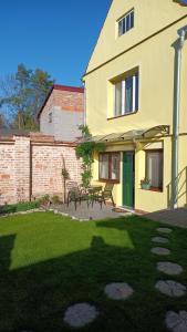 a yellow house with a green door and a yard at Ubytování Ledňáček in Lednice