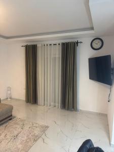 a living room with a tv and a couch and a clock at Lux Villa Azur in Bar