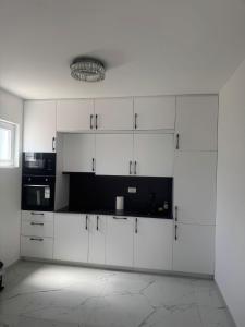 a white kitchen with white cabinets and a microwave at Lux Villa Azur in Bar