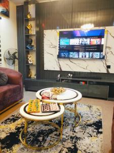 a living room with a table and a tv at Avapartmentrentals in Okunola