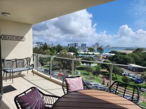a balcony with a table and chairs and a view of the ocean at The Dunes Cotton Tree in Maroochydore