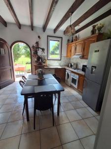 a kitchen with a table and a refrigerator at Maison de vacances en Corrèze in Saint-Pardoux-lʼOrtigier