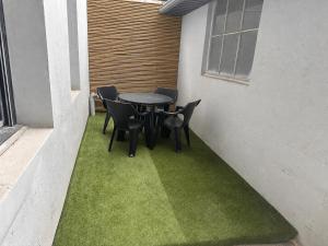 a patio with a table and chairs on grass at Aquero Lourdes T2 in Lourdes