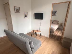 a living room with a couch and a mirror at Aquero Lourdes T2 in Lourdes