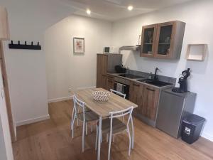 a kitchen with a table and chairs in a room at Aquero Lourdes T2 in Lourdes