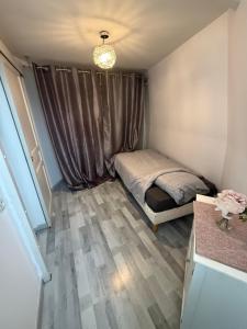 a small bedroom with a bed and a window at Appartement in Roubaix