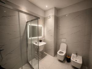 a bathroom with a shower and a toilet and a sink at ARMAS Stay in Kamëz +20 photos