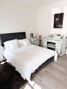 a bedroom with a large white bed and a desk at The lodge in Rushbrooke