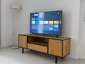 a flat screen tv sitting on top of a wooden entertainment center at Lavandula in Xanthi