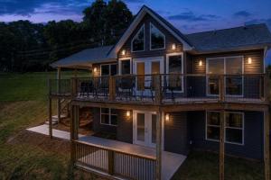 a house with a wrap around deck at night at Broadview, River, Golf Course, Games, free Attraction Tickets, WIFI!!! in Kodak
