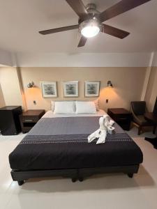 a teddy bear laying on a bed in a bedroom at Hotel Posada de Santiago in Tijuana