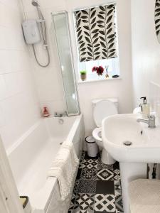 a bathroom with a tub and a sink and a toilet at The lodge in Rushbrooke