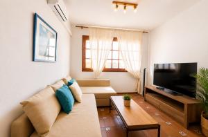 a living room with a couch and a flat screen tv at Deluxe Mogán Beach Apt 2 in Puerto de Mogán