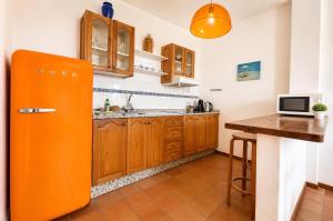 an orange refrigerator in a kitchen with a table at Deluxe Mogán Beach Apt 2 in Puerto de Mogán