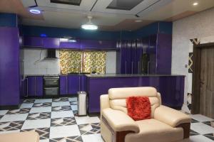 a kitchen with purple cabinets and a chair with a red pillow at Zions Apartments in Elephant Island