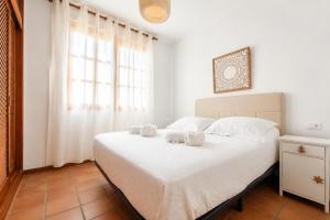 a bedroom with a bed with two towels on it at Deluxe Mogán Beach Apt 2 in Puerto de Mogán