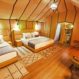 a bedroom with two beds in a room at Sahara Sky Luxury Camp in Merzouga