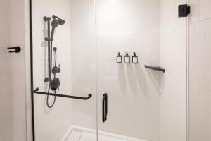 a bathroom with a shower with a glass door at Revival English Bay, Vancouver in Vancouver