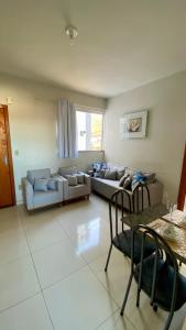 a living room with a couch and a table and chairs at Apto Aconchego no Coração de Capitólio condomínio residencial in Capitólio