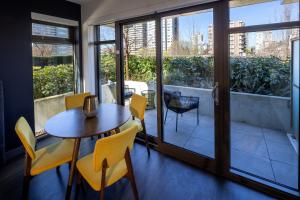a dining room with a table and chairs and a balcony at Revival English Bay, Vancouver in Vancouver
