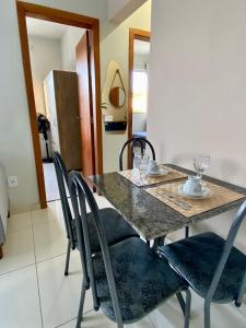 a dining room table with chairs and glasses on it at Apto Aconchego no Coração de Capitólio condomínio residencial in Capitólio +32 photos