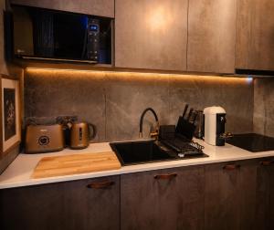 a kitchen counter with a sink and a microwave at JACUZZI & SAUNA Apartament Warszawa Wola in Warsaw