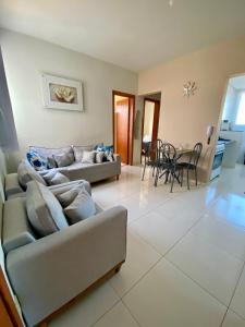 a living room with two couches and a dining room at Apto Aconchego no Coração de Capitólio condomínio residencial in Capitólio
