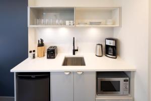 a kitchen with a sink and a microwave at Revival English Bay, Vancouver in Vancouver +25 photos