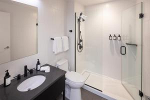 a bathroom with a toilet and a sink and a shower at Revival English Bay, Vancouver in Vancouver