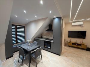 a dining room with a table and a tv at WOT Rose Residence in Arad