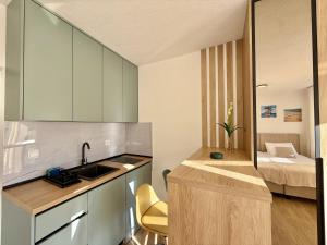 a kitchen with a sink and a bedroom with a bed at Modern Beachfront Apartment in Đenovići