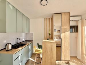 a kitchen with a sink and a kitchen with a bed at Modern Beachfront Apartment in Đenovići