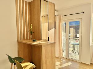 a room with a wooden partition with a table and a chair at Modern Beachfront Apartment in Đenovići +5 photos