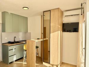 a kitchen with green cabinets and a sink at Modern Beachfront Apartment in Đenovići