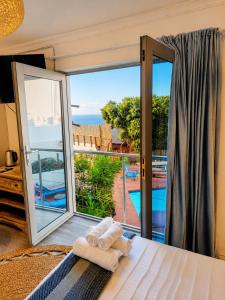 a bedroom with a bed and a view of a pool at VistaBlu Camps Bay in Cape Town