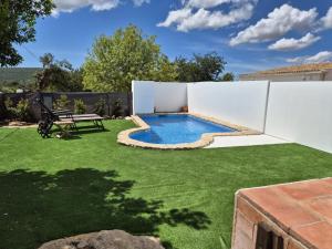 a backyard with a swimming pool and grass at Cosy Country House in Cerro da Cova