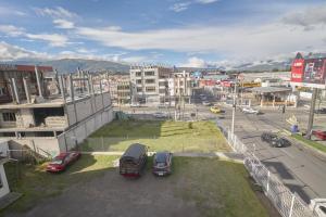 zwei Autos auf einem Parkplatz in einer Stadt geparkt in der Unterkunft Hotel Los Alamos in Riobamba