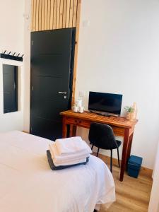 a bedroom with a desk and a bed with a computer at Chambre à soulac in Soulac-sur-Mer
