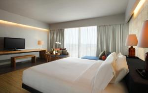 a hotel room with a large bed and a television at U Paasha Seminyak Bali in Seminyak