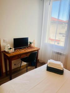 a bedroom with a desk with a computer on it at Chambre à soulac in Soulac-sur-Mer